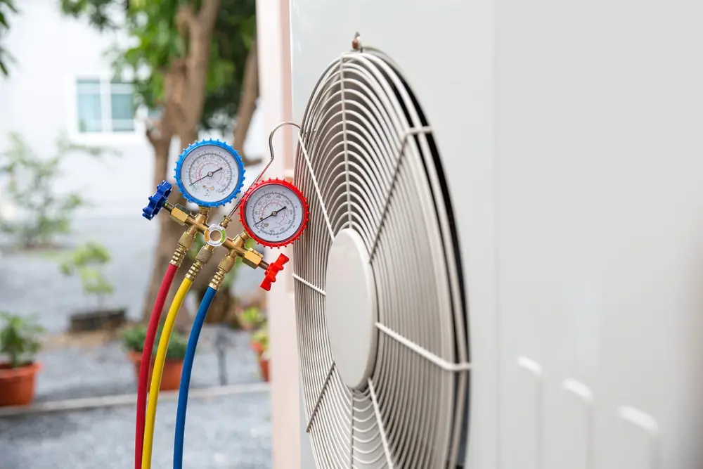 Technician diagnosing failed air conditioner during hot afternoon at Hall County home
