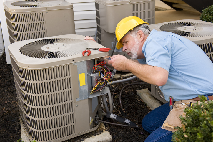 Experienced HVAC technician testing electrical components during urgent residential system repair
