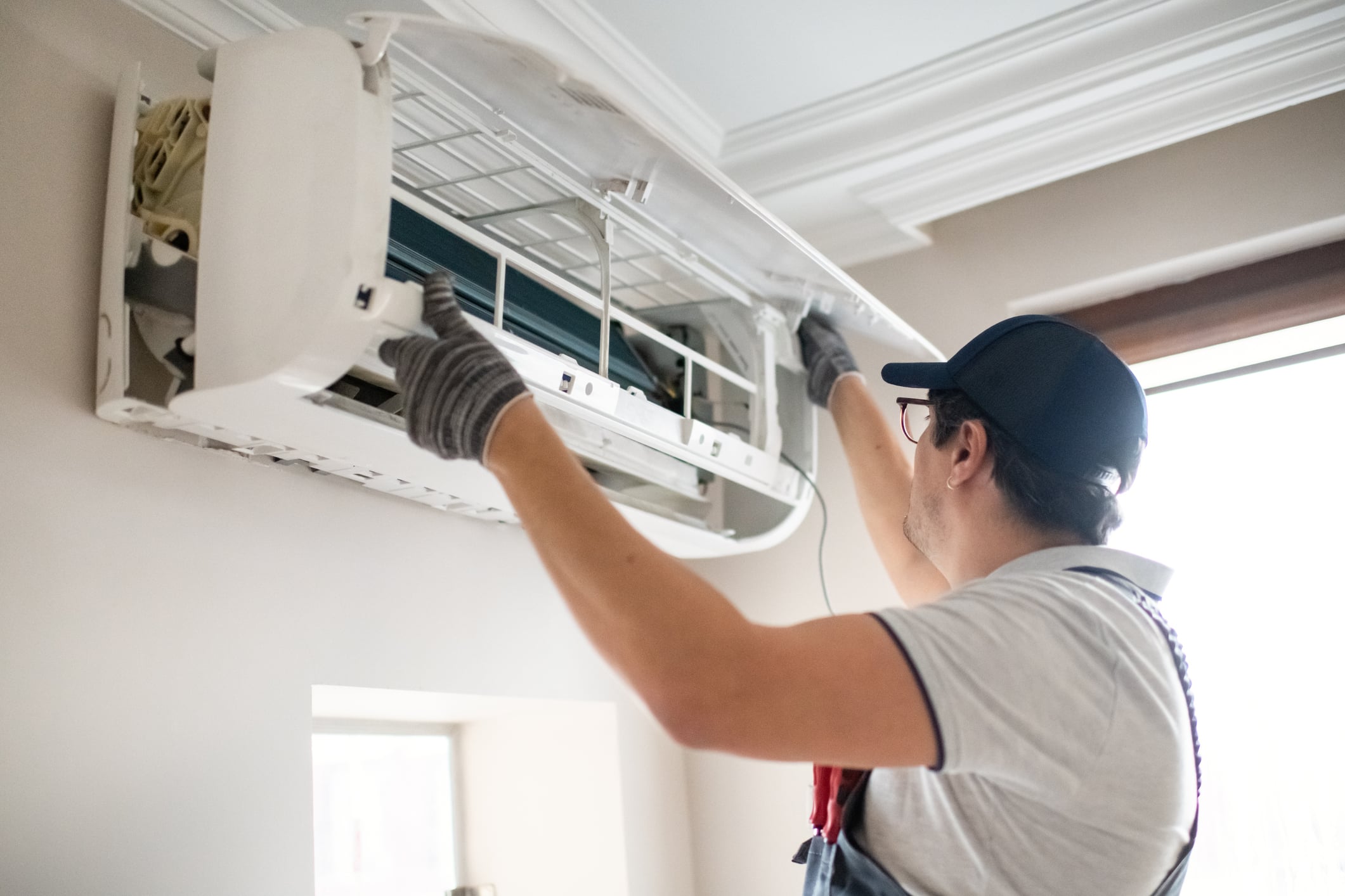 Technician measuring airflow and system fit before full residential HVAC replacement